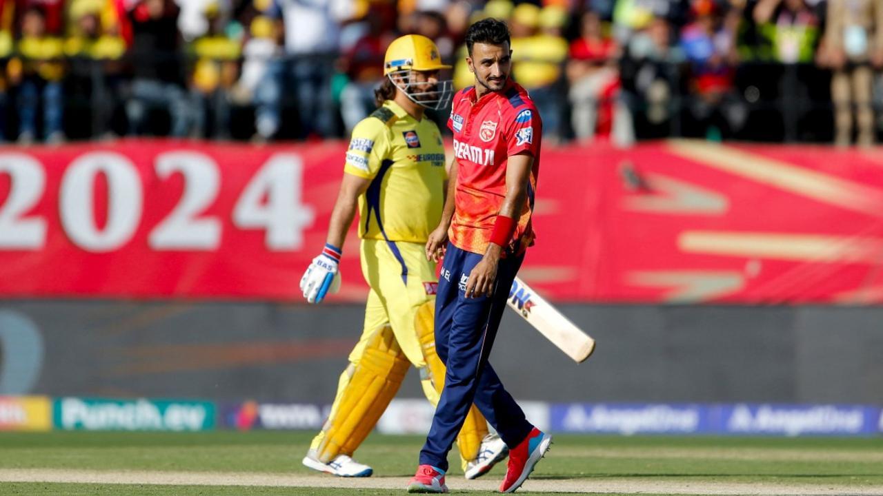 Punjab Kings` Harshal Patel (R) reacts after taking the wicket of Chennai Super Kings` MS Dhoni (L) / Pic: AFP