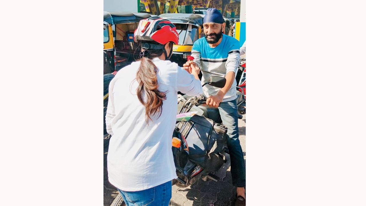 A cyclist presents a rose to a motorist during an awareness programme in the city