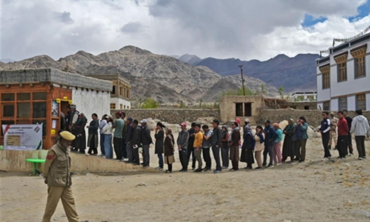 Voters line up in front of a voting booth in Thiksey, Leh. Two Union Territories- Ladakh and Jammu and Kashmir- go to the ballot in the India General Elections 2024.