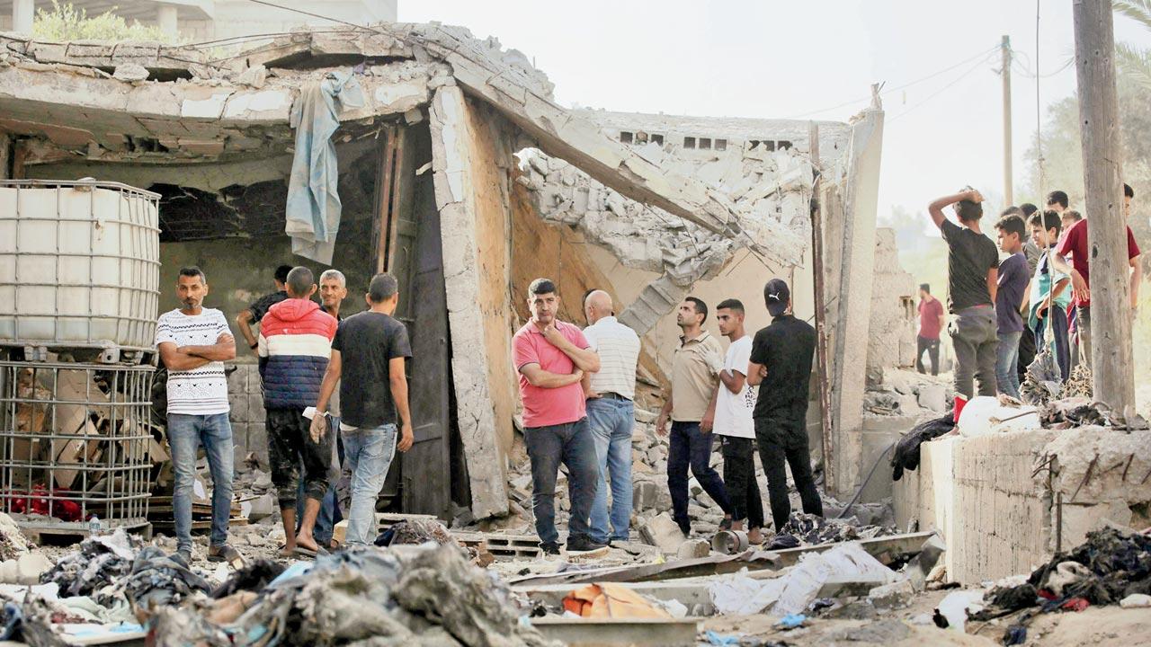 Palestinians gather outside a damaged house in central Gaza