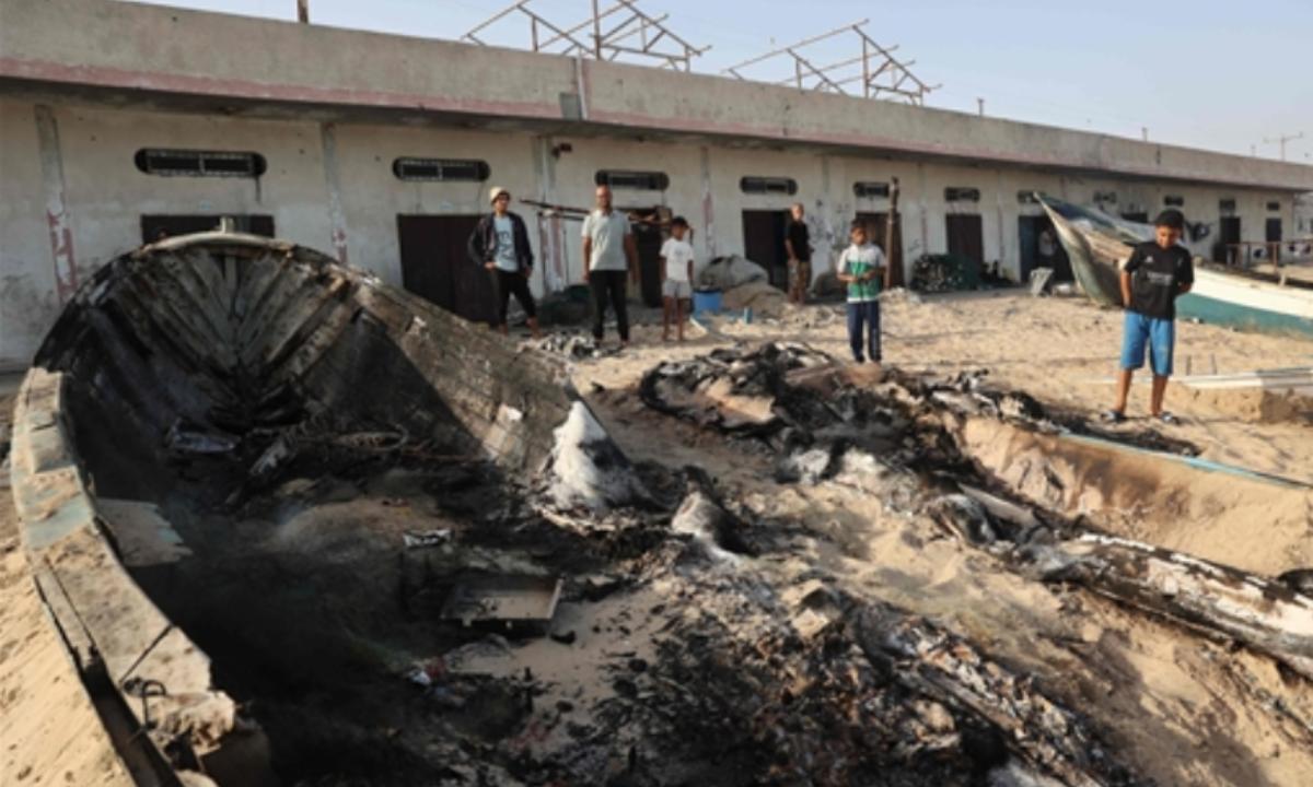 Meanwhile, Israeli airstrikes continue in the Gaza Strip on Wednesday, destroying infrastructure and modes of earning. Palestinians stand around a charred boat in this airstrike.