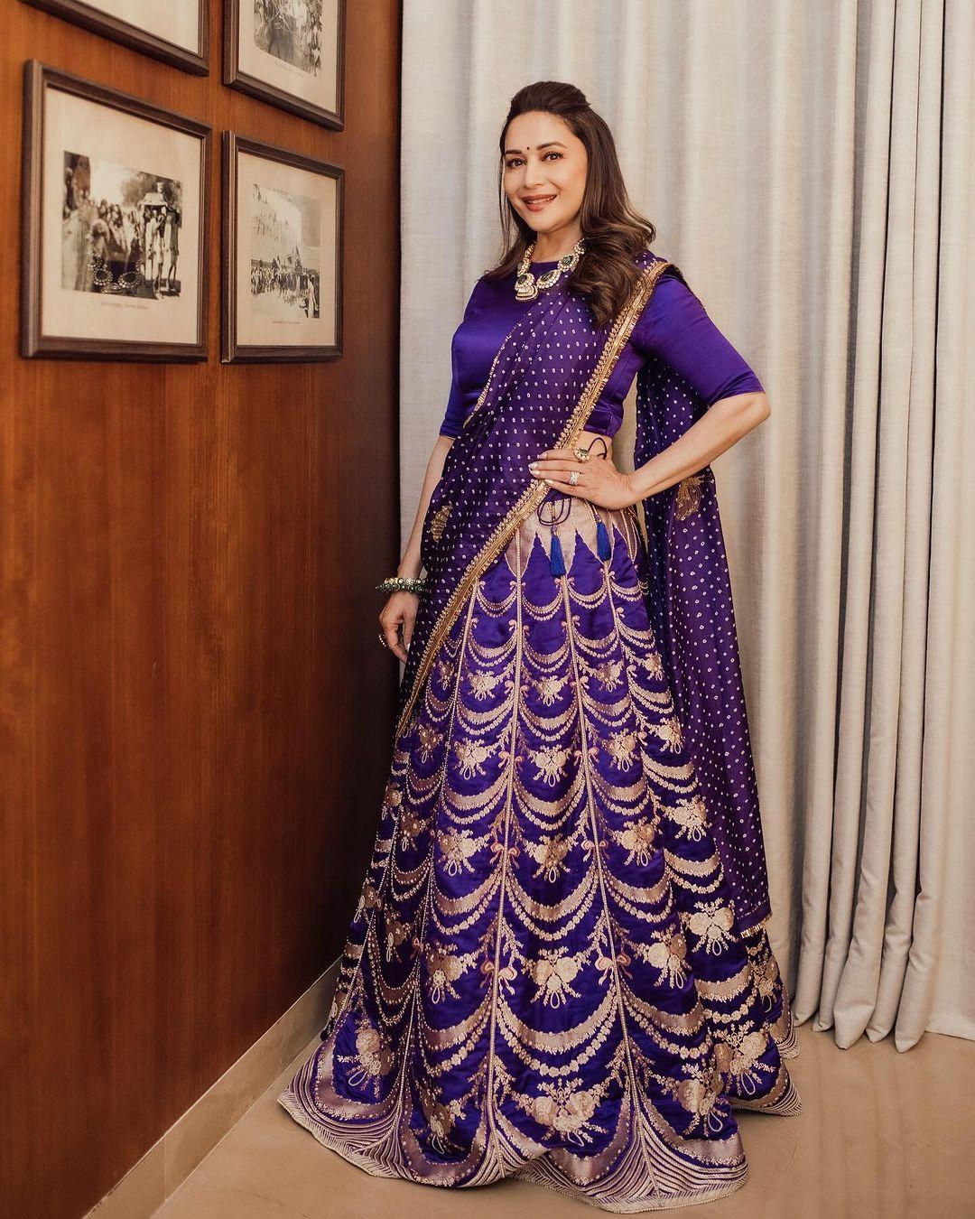Madhuri Dixit was stunning in a purple lehenga. Her blouse had long sleeves, and the skirt was beautifully embroidered all over