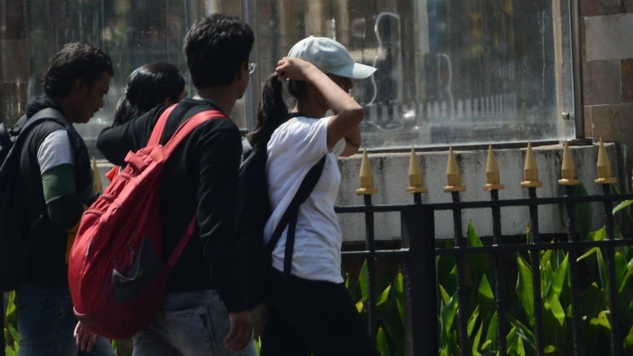 People were seen protecting themselves from the afternoon heat on Monday afternoon. Pics/Sameer Abedi