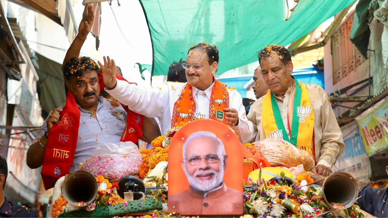 The roadshow attracted a large crowd of enthusiastic supporters who waved BJP flags, indicating strong backing for the party's candidate.