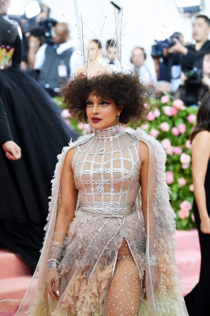 What really caught everyone's attention about Priyanka's appearance wasn't just her outfit, but her bold makeup and hairdo. She wore exaggerated eyelashes and an afro-inspired hairstyle. To top it off, she added a metallic cage-like crown nestled within her curls.