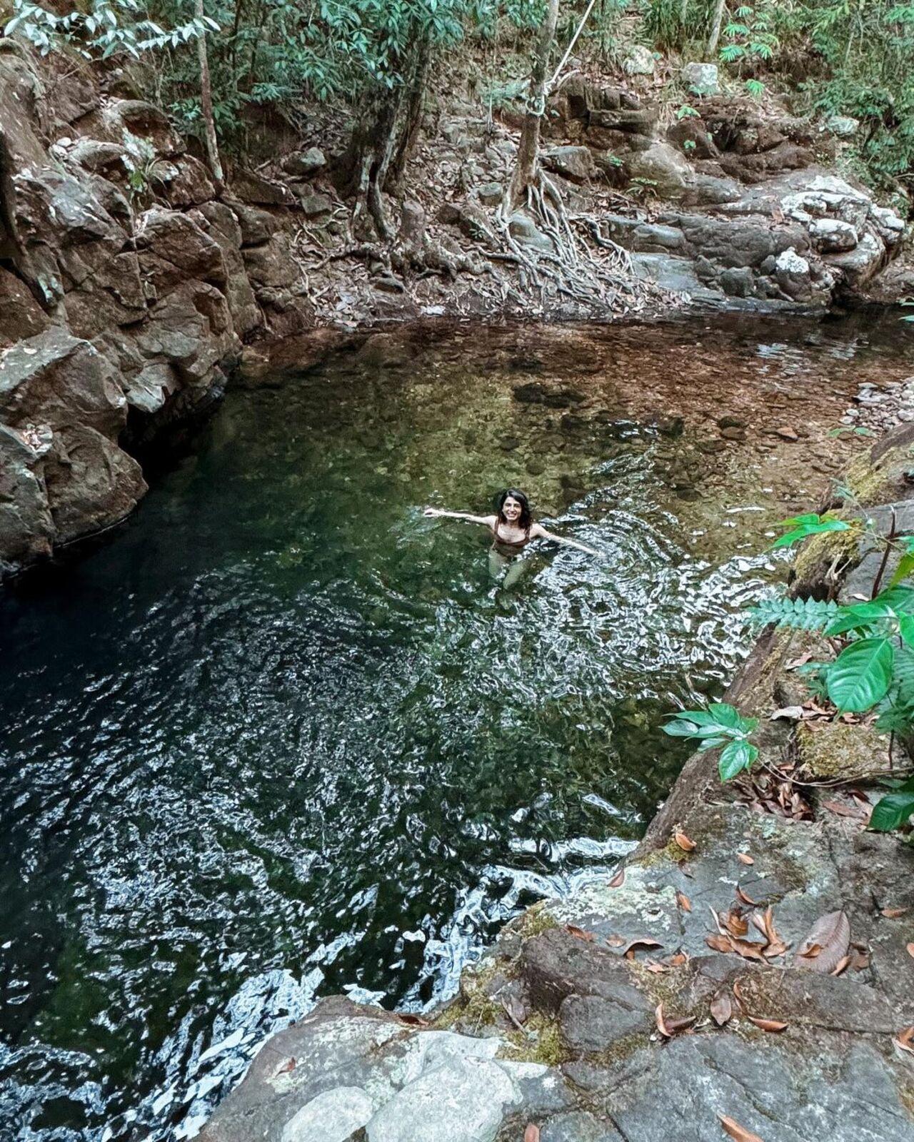 Samantha takes a swim in a stream in the midst of a Malaysian forest