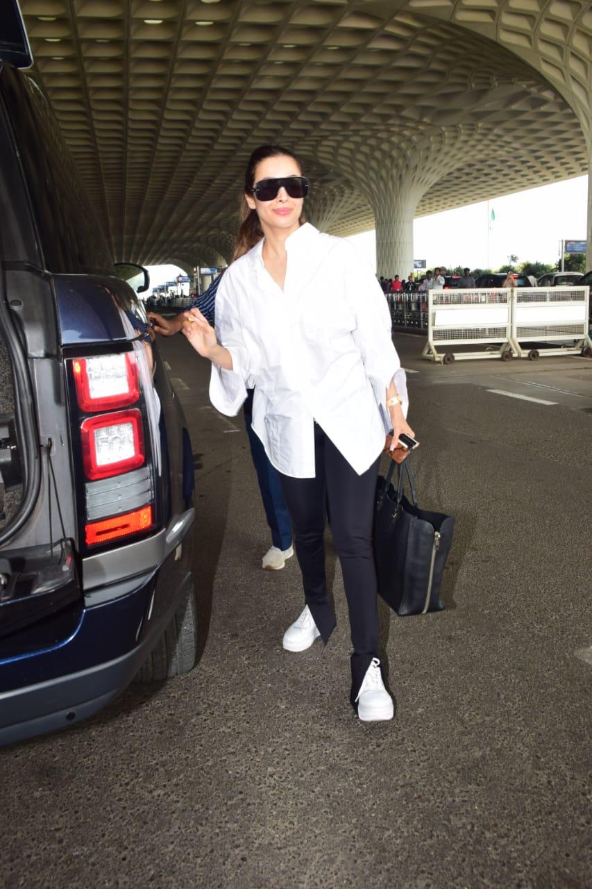 Malaika Arora was seen jetting off from the city. The actress wore a simple white shirt and black pant for her airport look