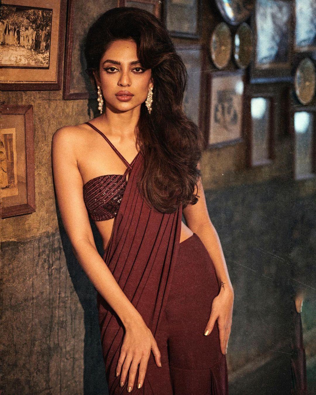 Her winged eyeliner gave a vintage vibe, while kohl-rimmed eyes, highlighted cheekbones, dewy makeup, and glossy nude lips completed her retro look perfectly.