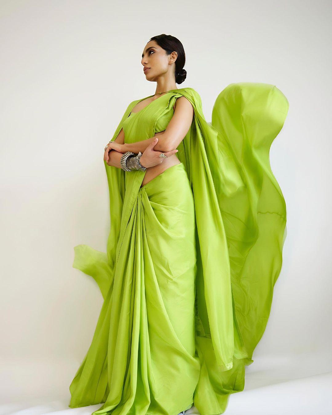 While the saree itself was impressive, the standout feature was the long, flowing lime-green cape draped over her shoulders and back.