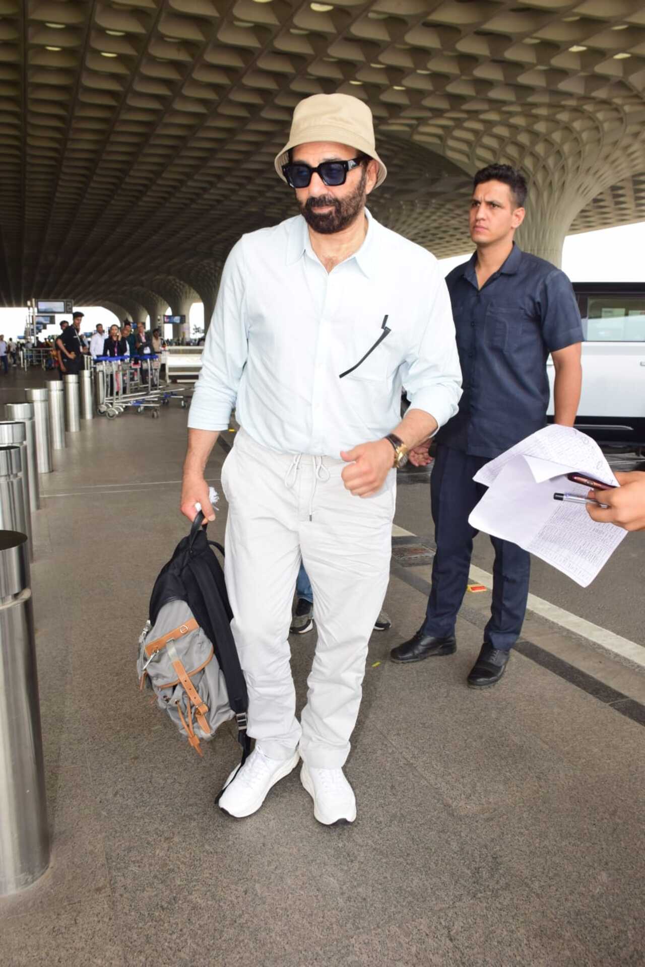‘Gadar 2’ star Sunny Deol was spotted at the Mumbai airport in an all-white ensemble with his signature bucket hat. 