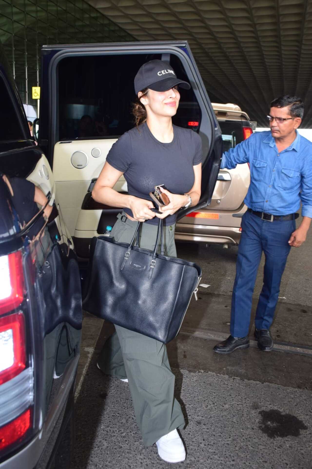 Style icon Malaika Arora looked chic in a black t-shirt and grey cargo pants as she sashayed in style at the Mumbai airport. 