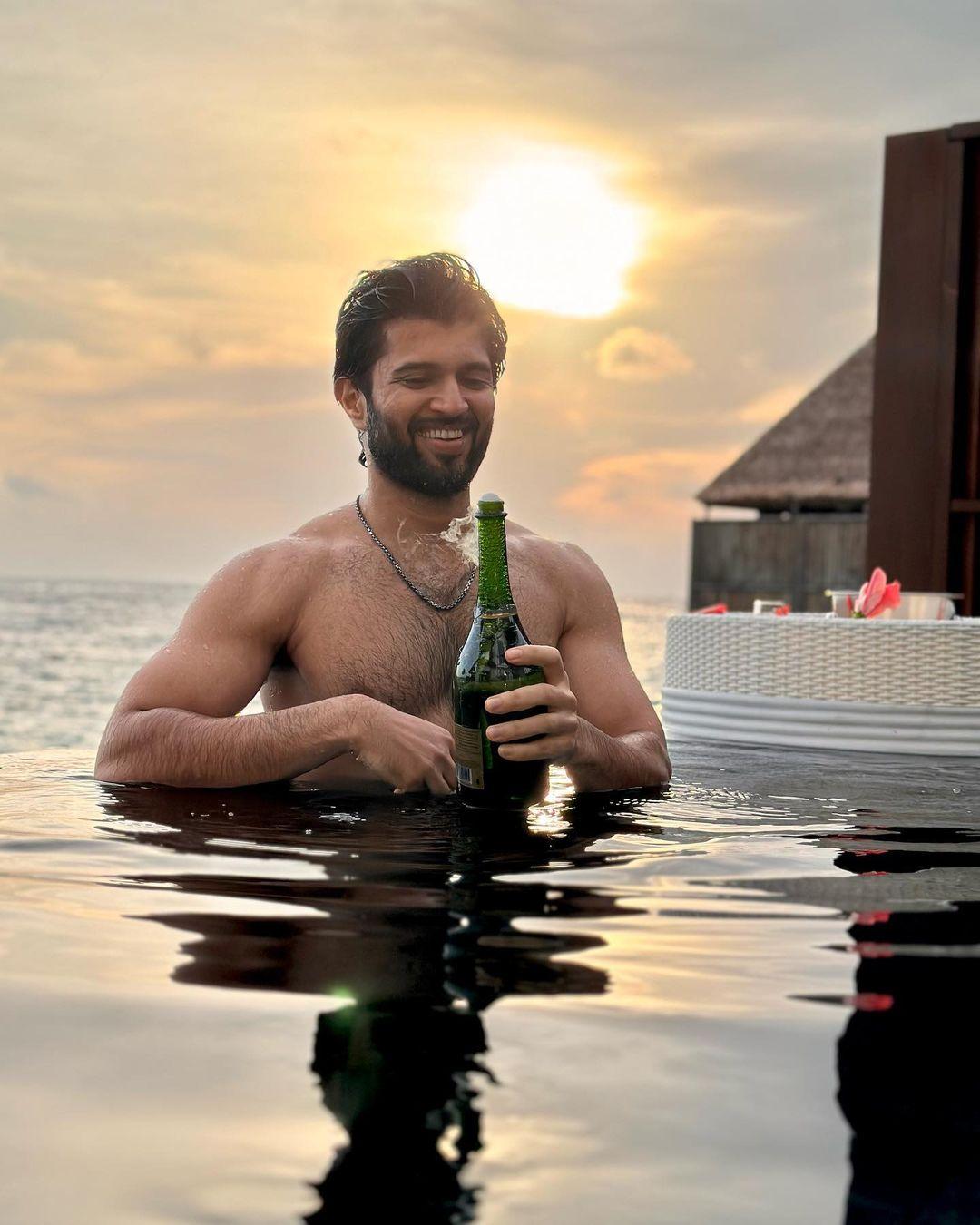 Vijay Deverakonda's laid-back summer vibe is on full display as he enjoys a carefree moment poolside, shirtless and relaxed. 