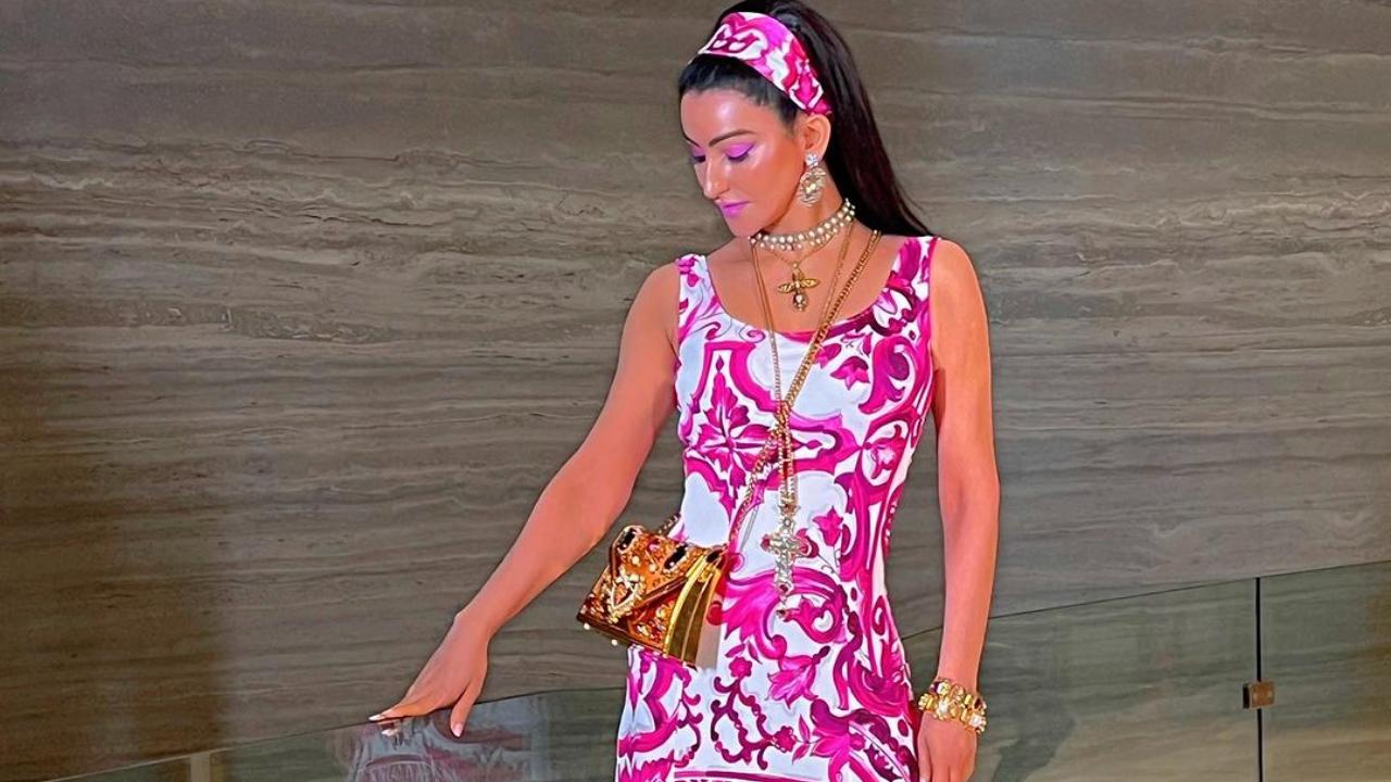 Passi goes retro in this pink and white dress. The headband completes her look, with a golden bag and jewellery. The vibrant pink make-up is the highlight of the look. 