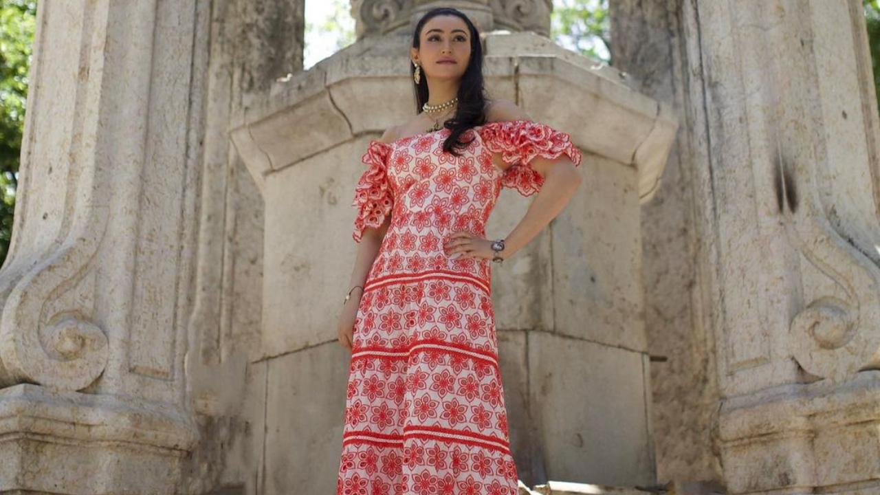In this throwback picture from Lisbon, Passi looks stunning in a red and white floral off-shoulder dress. 