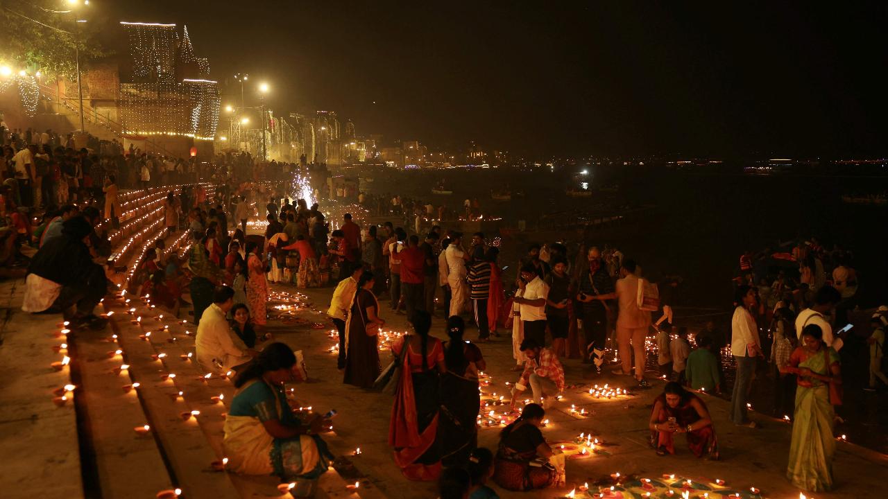 Devotees light earthen lamps as they celebrate Dev Deepawali on the banks of the river Ganges in Varanasi