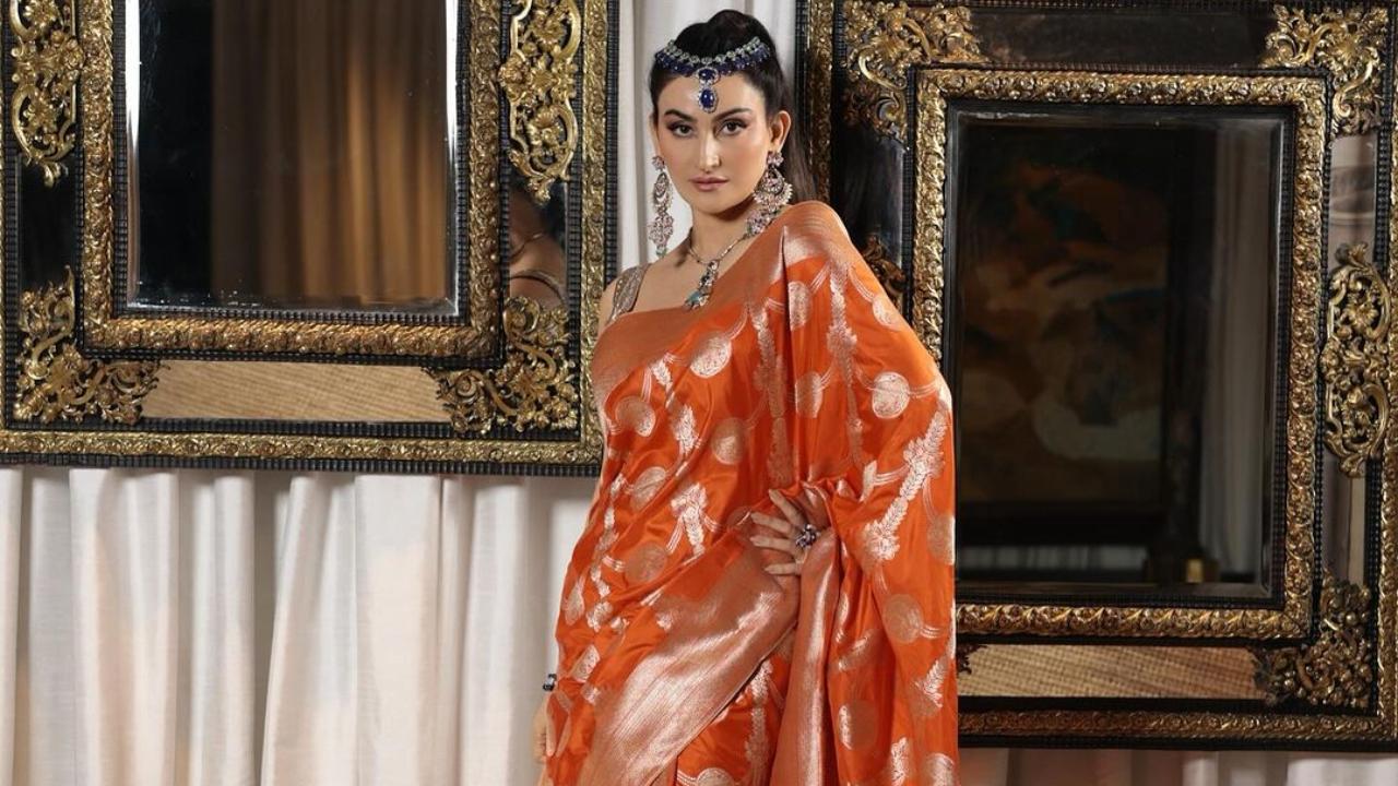 In this Diwali picture, Passi opts for an orange Banarasi saree, featuring delicate rose gold zari work. She styles it with a rose gold Gota blouse and exquisite art deco jewellery. 