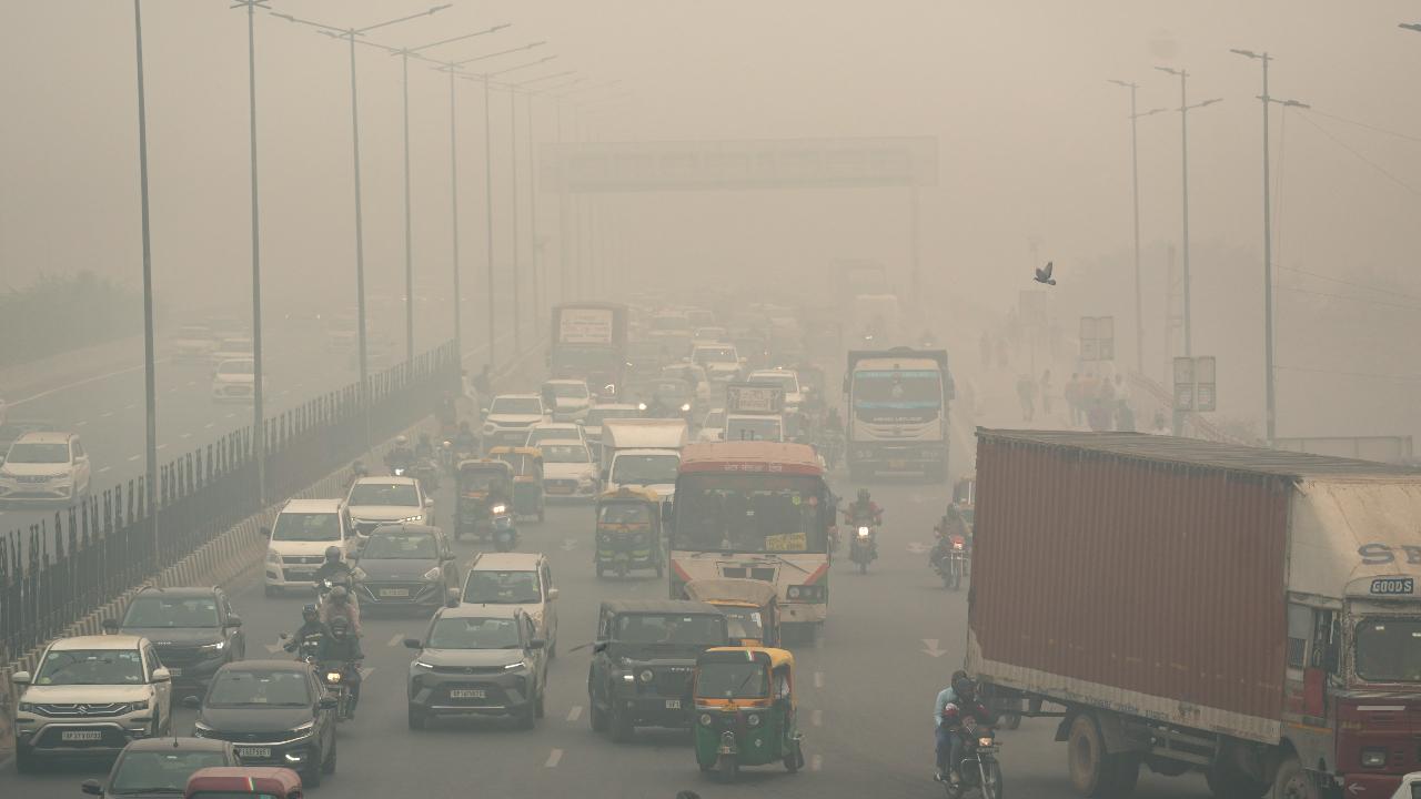 Vehicles on a road amid smog in the city
