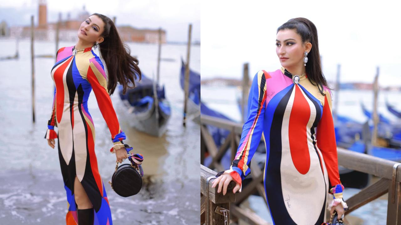 In these pictures from Venice, Passi redefines vacation fashion wearing a colourful, full-sleeved dress with a thigh-high slit. She completes her look with a black bag and high boots. 