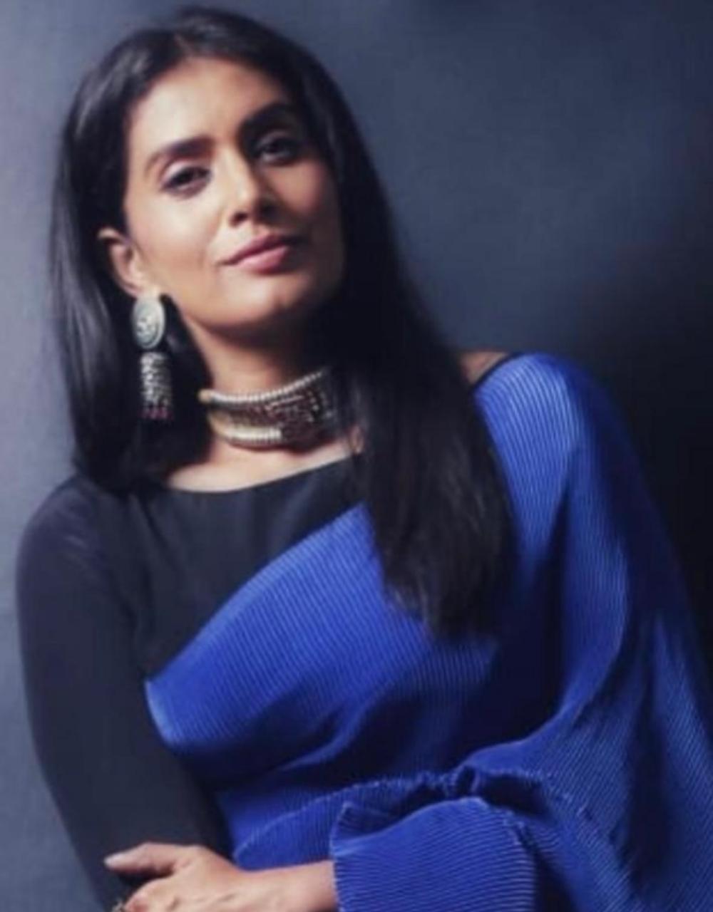This look, featuring a royal blue self-pleated saree with a contrasting boat necked, three quarter sleeved black blouse, embodies a range from board room to banquet. The art deco tribal jewellery adds a flair to the entire look.