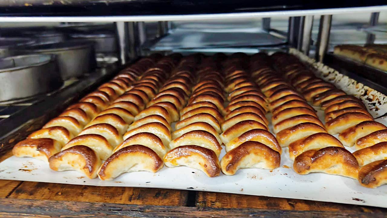 A worker readies trays of marzipan, coating them with egg before they are popped into the oven for three to four minutes