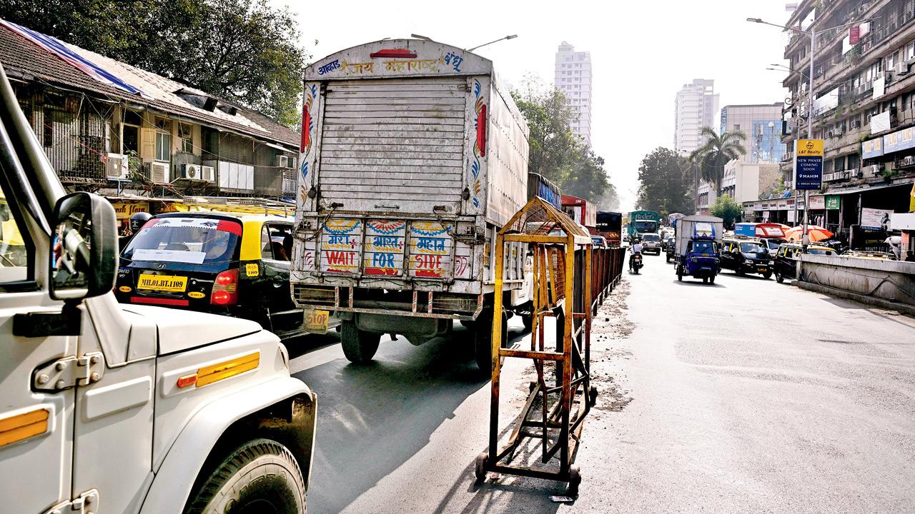Iron railings being installed on the flyover; bikers use the gaps in between the barracades and ride on wrong side because of the jam