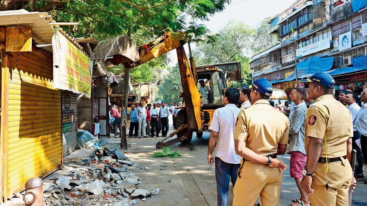 The authorities demolish illegal structures on the road on Friday. Pics/Nimesh Dave