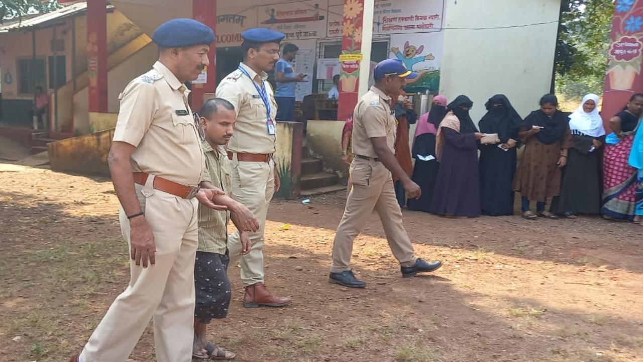 A person with disability is assisted by the personnel deployed at a polling centre in Ratnagiri