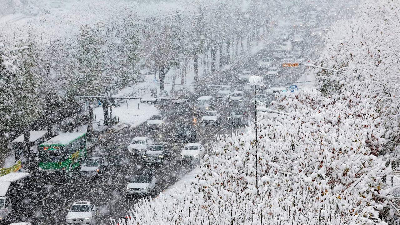 Cars move slowly on a snow-covered road. Pics/AP