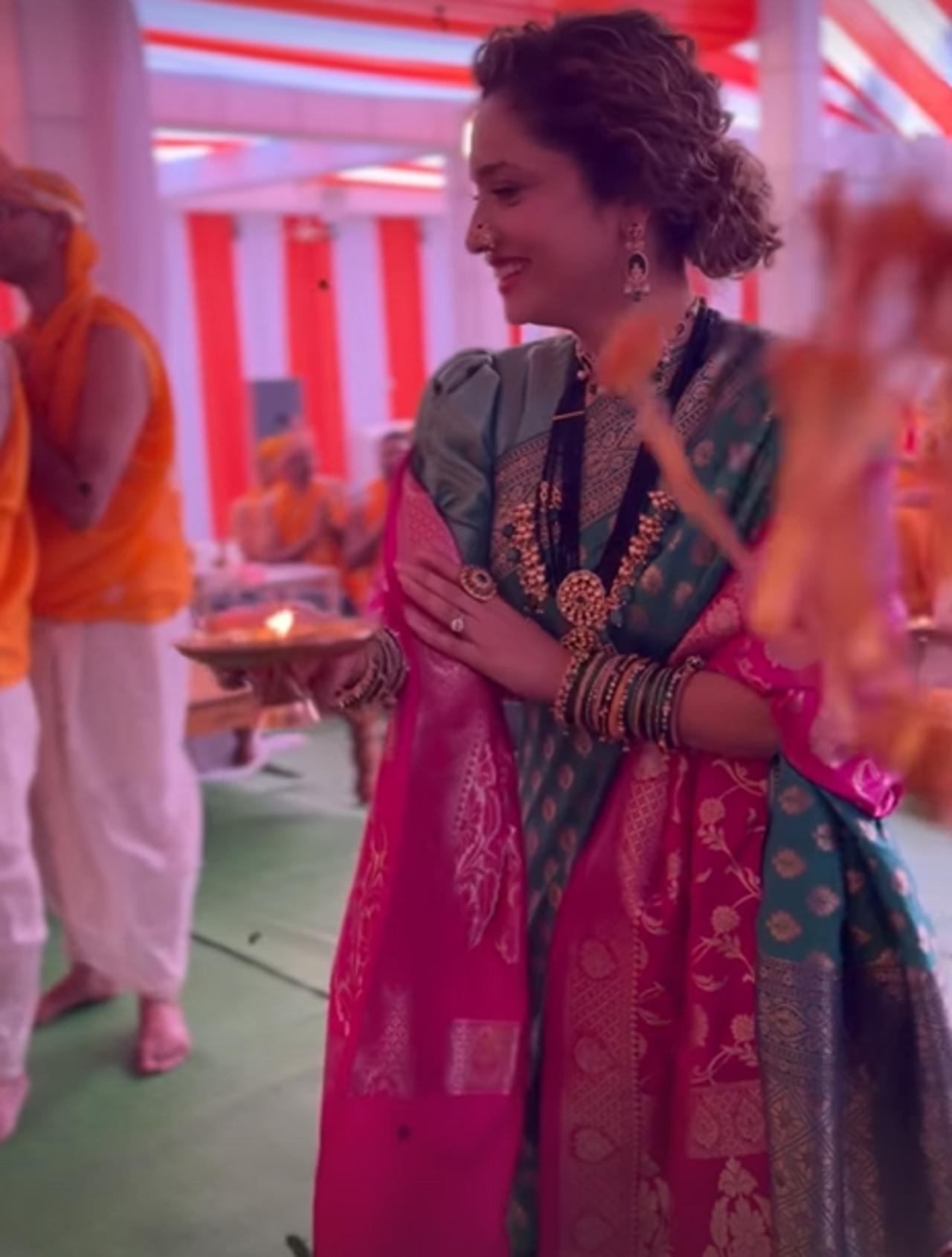 She wore a beautiful green saree adorned with delicate prints, adding a soft pink shawl draped over her shoulders, which provided an extra touch of elegance to her ensemble