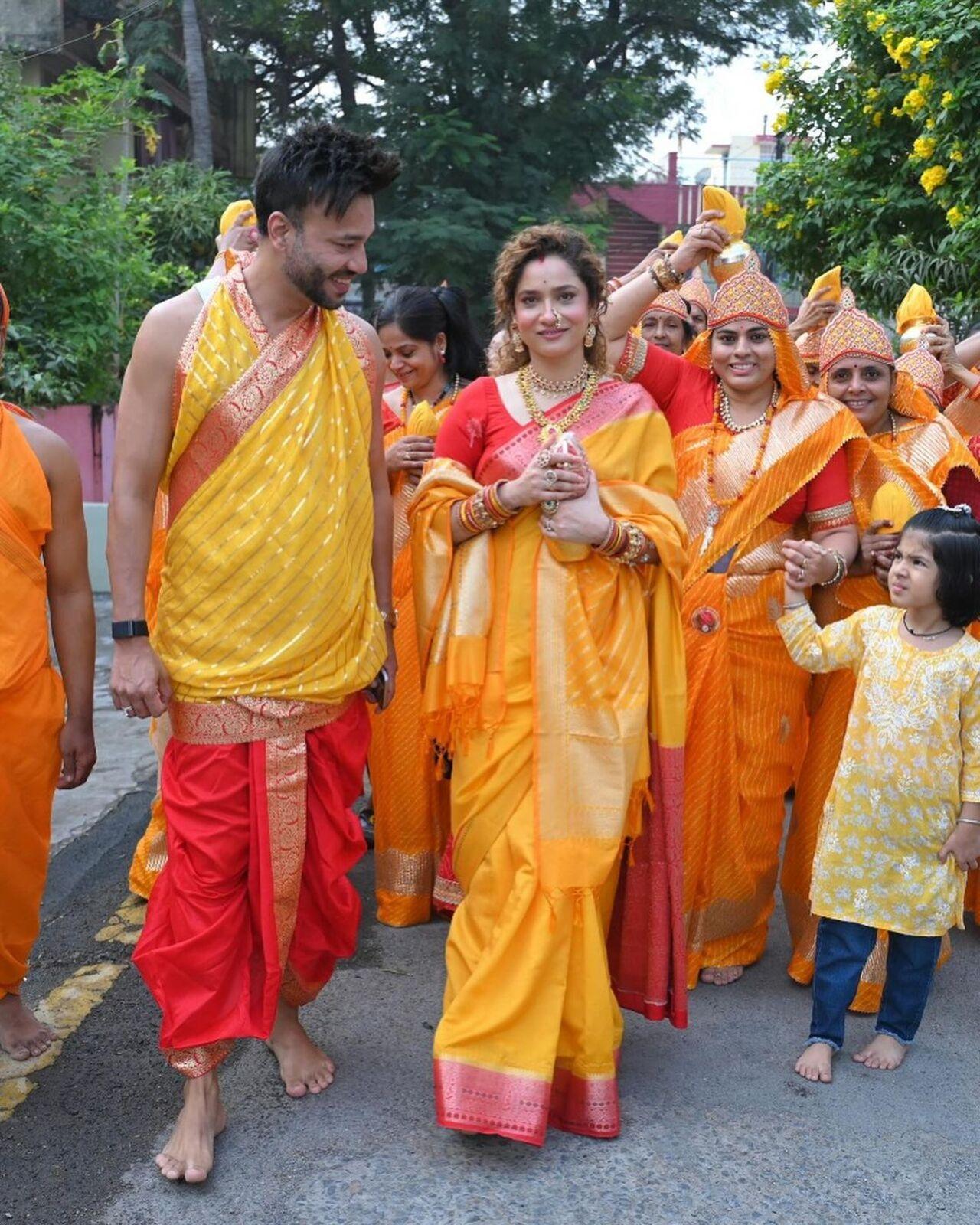 In one picture, Ankita Lokhande and Vicky Jain are seen wearing traditional yellow and red-colored outfits. Ankita is dressed in a yellow saree with a red border and intricate designs, while Vicky is wearing a dhoti and has covered his upper body with a yellow dupatta