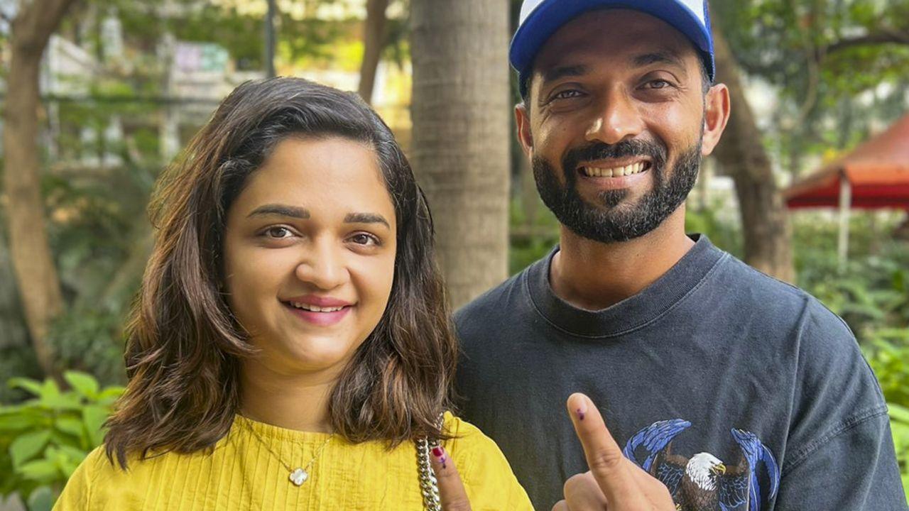 Cricketer Ajinkya Rahane with his wife shows his inked finger after casting vote during the Maharashtra Assembly elections. (Pic courtesy: PTI)