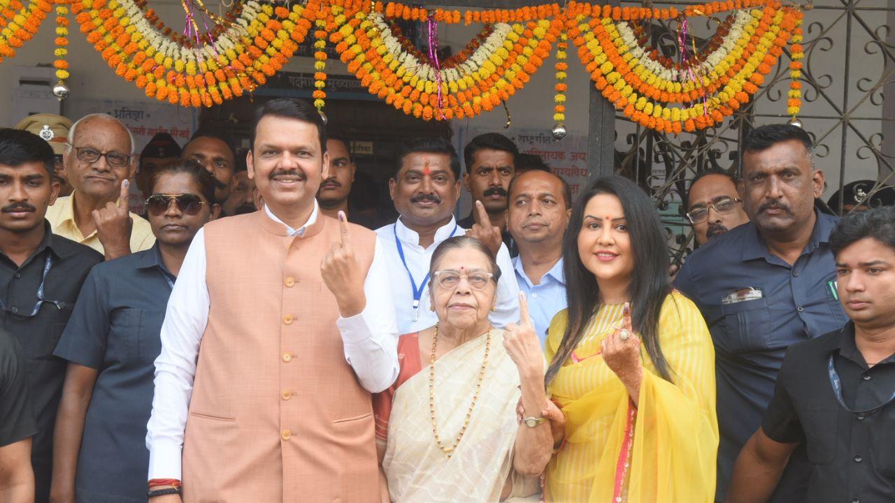 Maharashtra Deputy CM & BJP candidate from Nagpur South-West Assembly seat, Devendra Fadnavis, his wife Amruta Fadnavis and mother Sarita Fadnavis show their inked finger after voting for #MaharashtraElections2024, at a polling booth in Nagpur. (Pic courtesy: PTI)