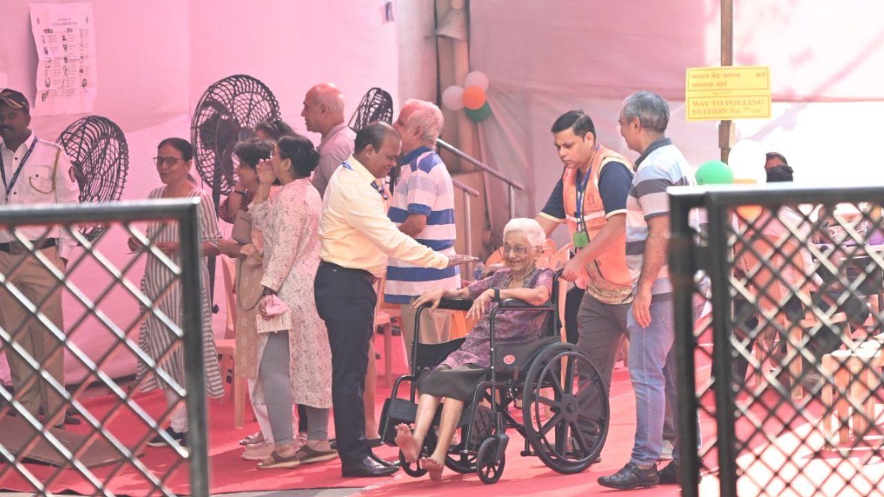 A senior citizen receives assistance from EC officials at a polling booth in Santacruz East, Mumbai. (Pic courtesy: Sayyed Sameer Abedi)