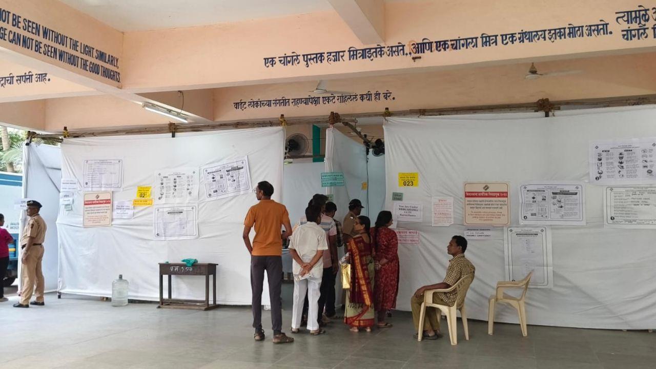The people wait in queue outside polling booth to cast their vote for Maharashtra Assembly elections in Mumbai's Sion 