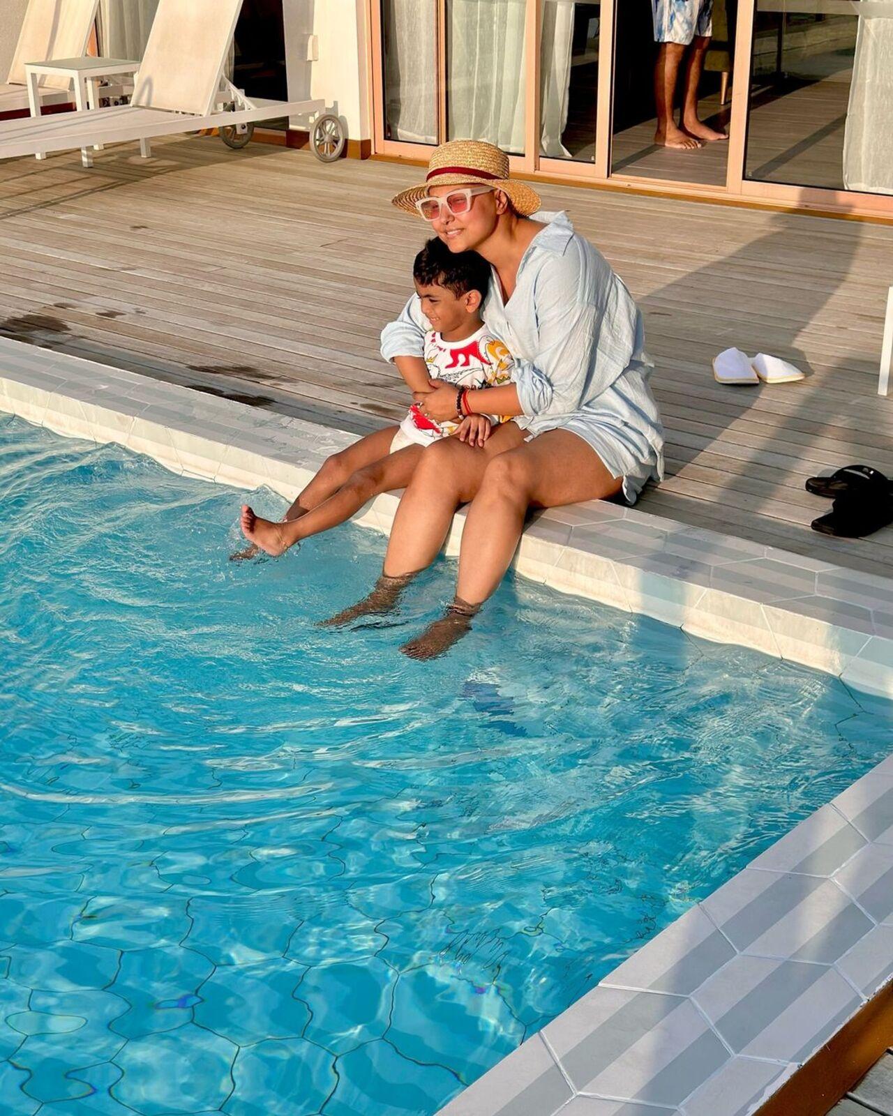 Hina poses with a little kid by the pool attached to her room