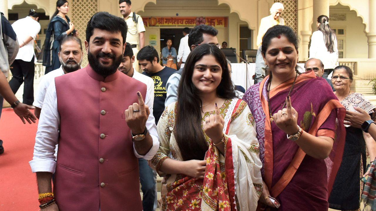 MoS Murlidhar Mohol with family members shows his ink-marked finger after casting vote during the Maharashtra Assembly elections, in Pune (Pic courtesy: PTI)