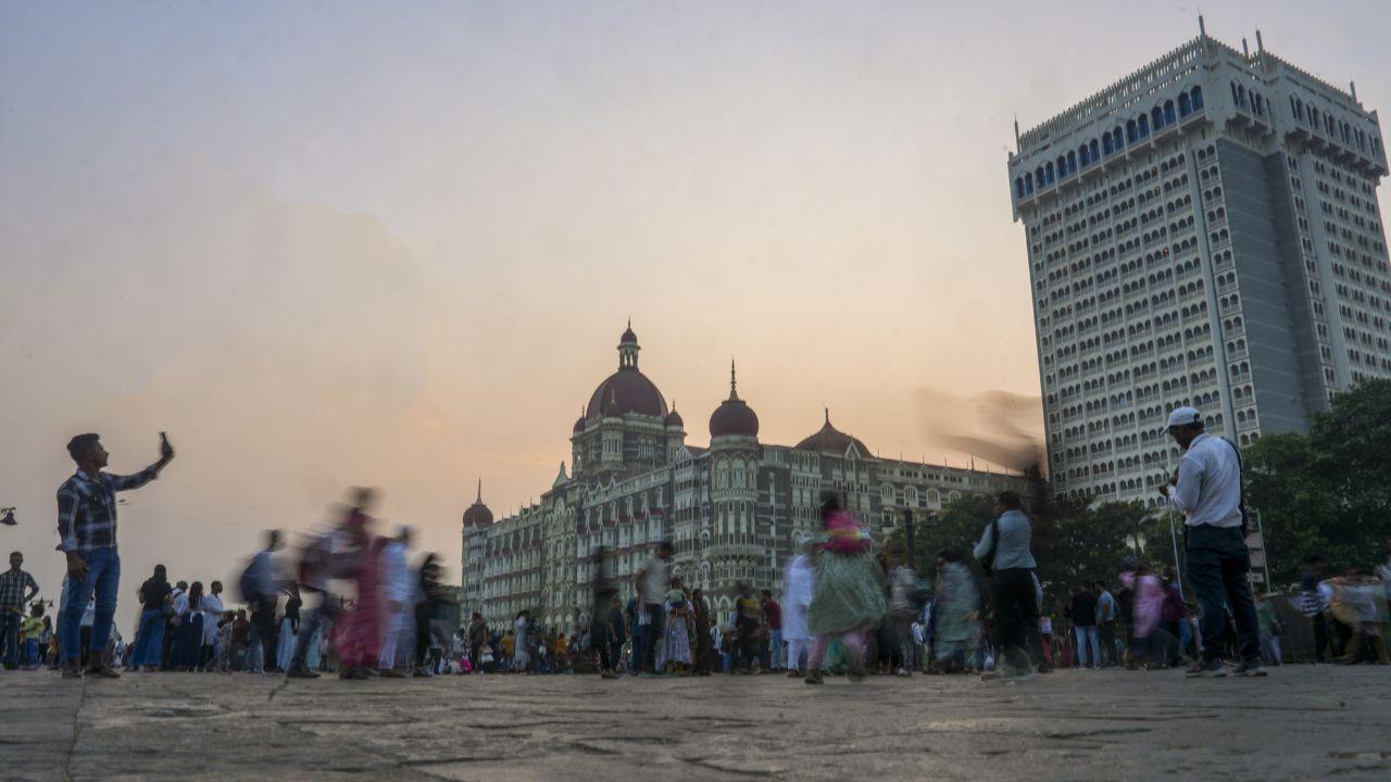 People outside Taj Mahal Palace hotel, one of the sites of the 26/11 Mumbai terror attacks, on the eve of the anniversary of the gruesome incident, in Mumbai on Monday. (Pic/PTI)