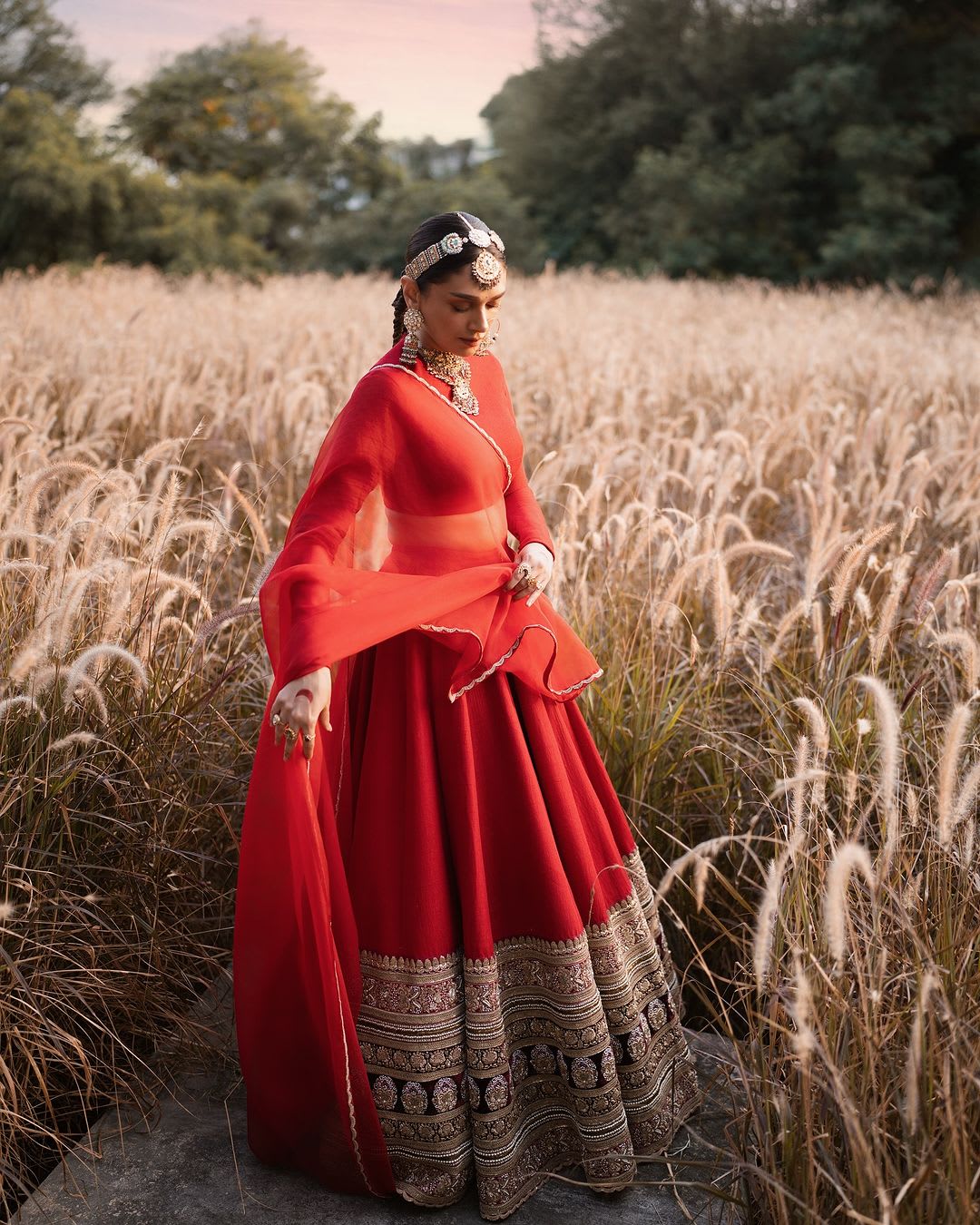 Aditi Rao Hydari's bridal look included a handcrafted silk lehenga from the Sabyasachi Heritage Bridal collection, paired with an organza dupatta and matching jewelry, including a matha patti, nose ring, and gold ornaments.