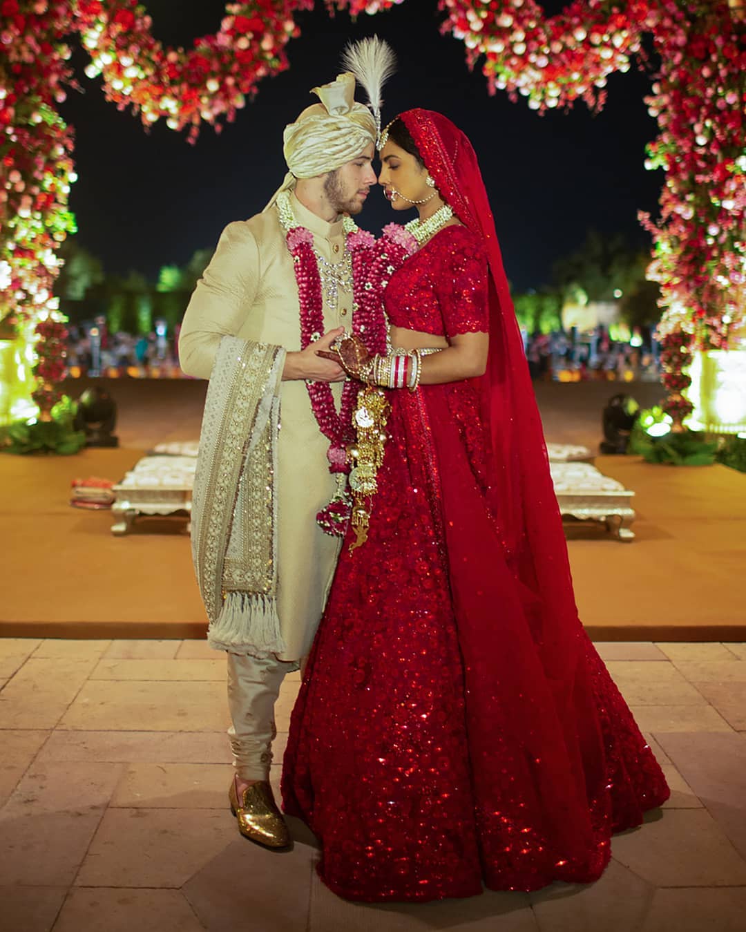 For her Hindu wedding ceremony on Sunday, Priyanka Chopra chose a deep red lehenga, choli, and dupatta, embodying the perfect 'desi' bride with traditional elements like the chooda, kaleerein, and garland. Nick complemented her look with a sherwani and turban.
