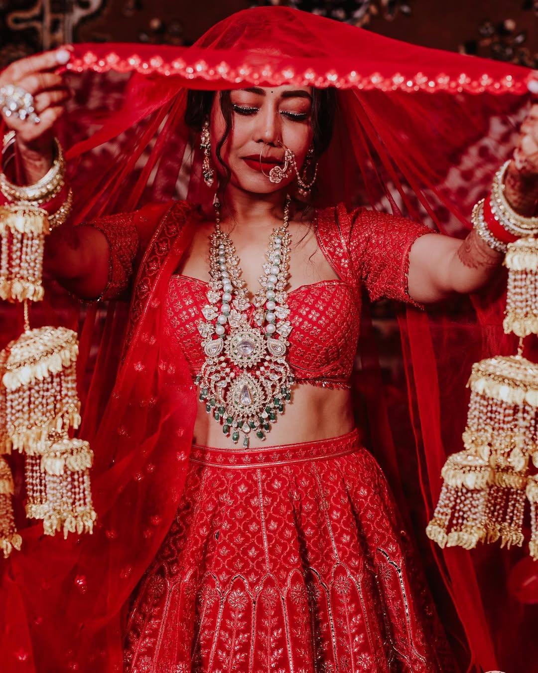 Neha Kakkar’s red bridal lehenga by Falguni Shane Peacock gained attention for its resemblance to Priyanka Chopra’s crimson wedding ensemble, making her styling stand out.
 