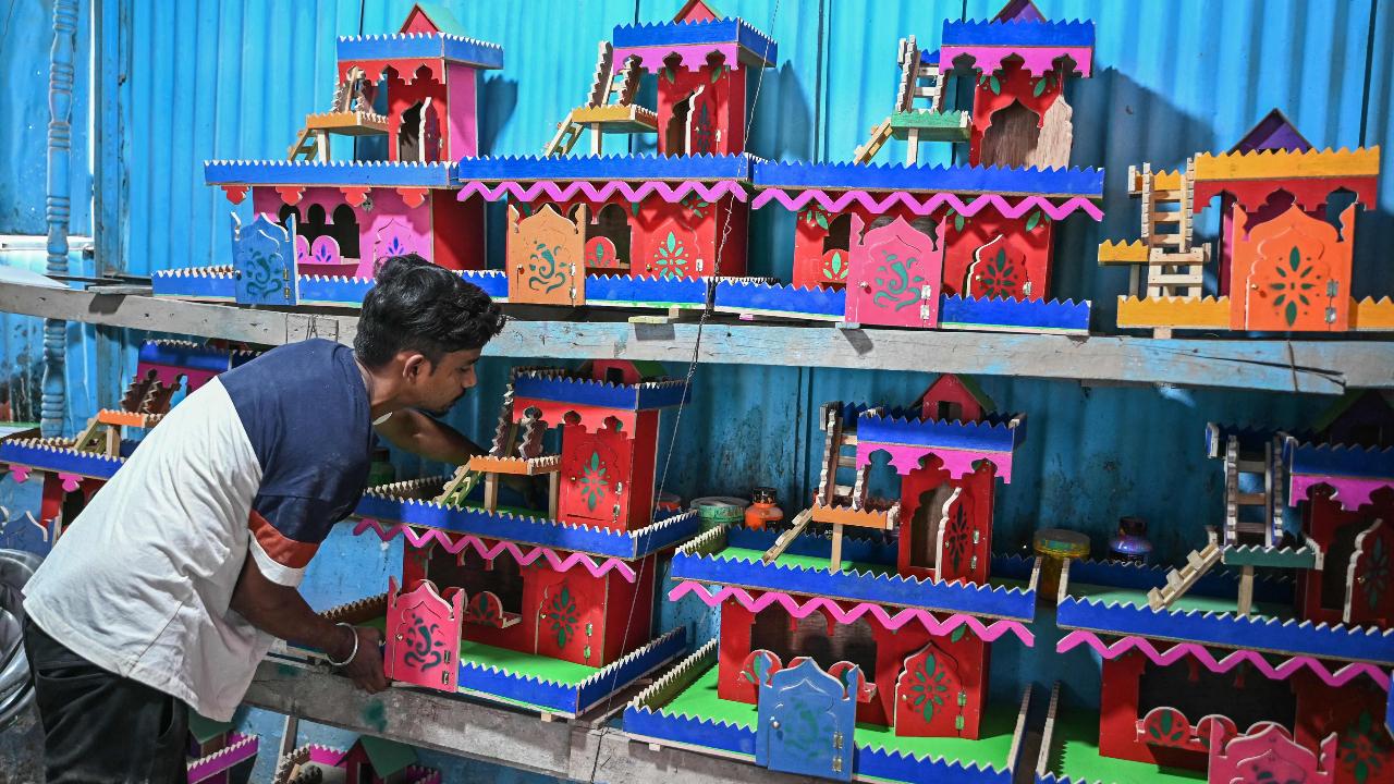 An artist displays miniature houses traditionally called as 'Gharonda' prepared for rituals for Diwali in Hyderabad