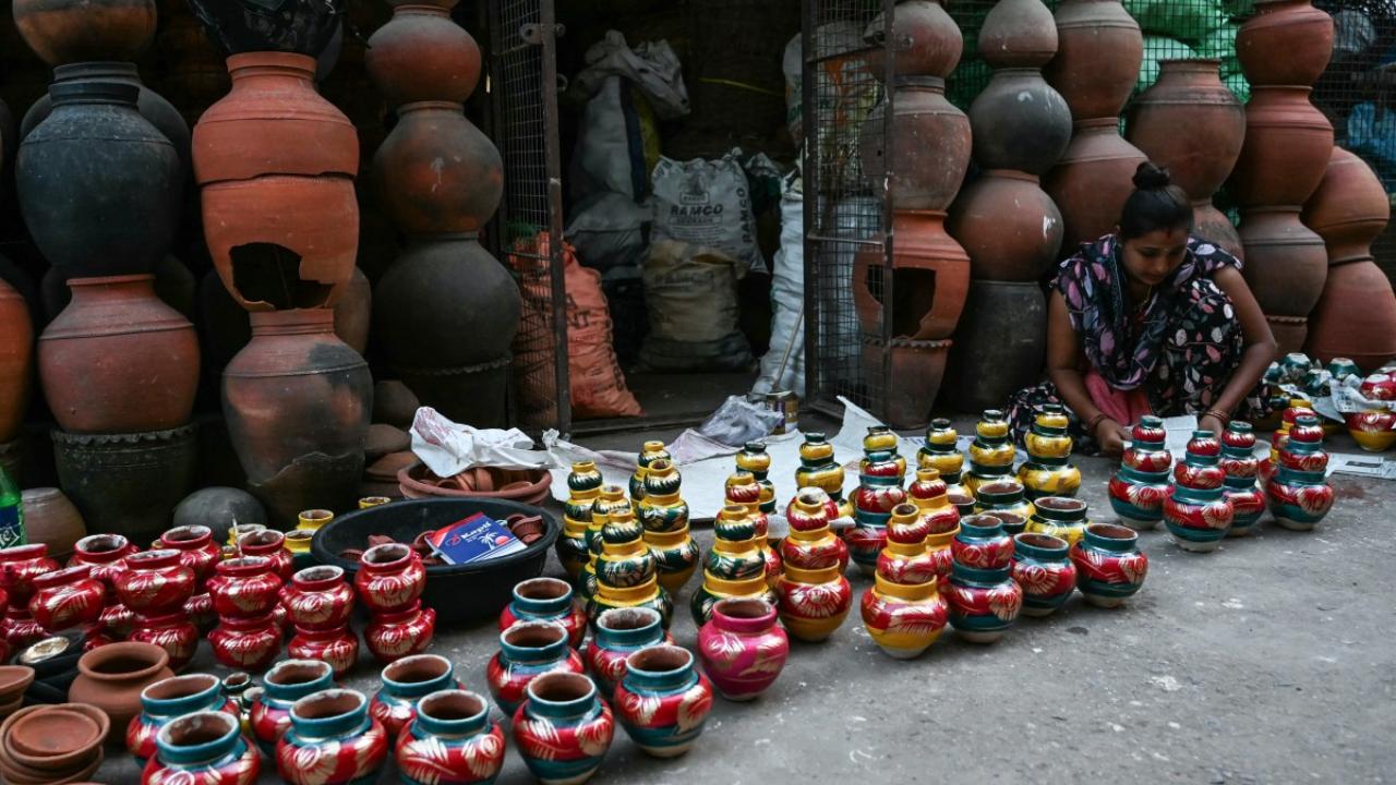 An artisan packs diyas after applying colours on them at her workshop in Hyderabad
