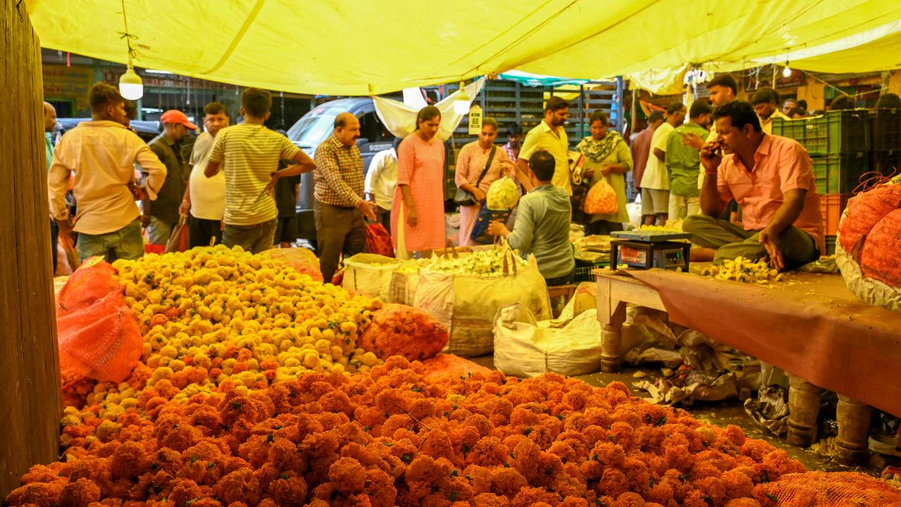 People buy flowers at a wholesale market on the eve of Diwali in Hyderabad 
