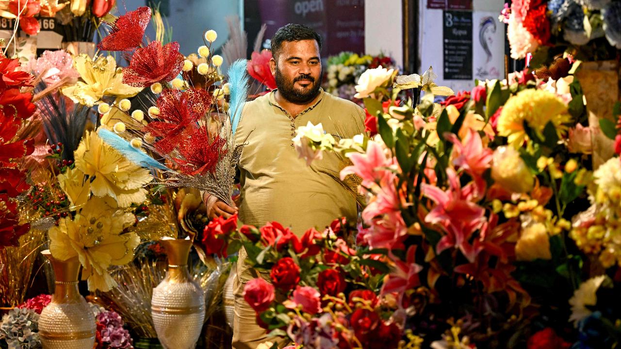 A shopkeeper sells artificial flowers ahead of Diwali at a local market in Faridabad