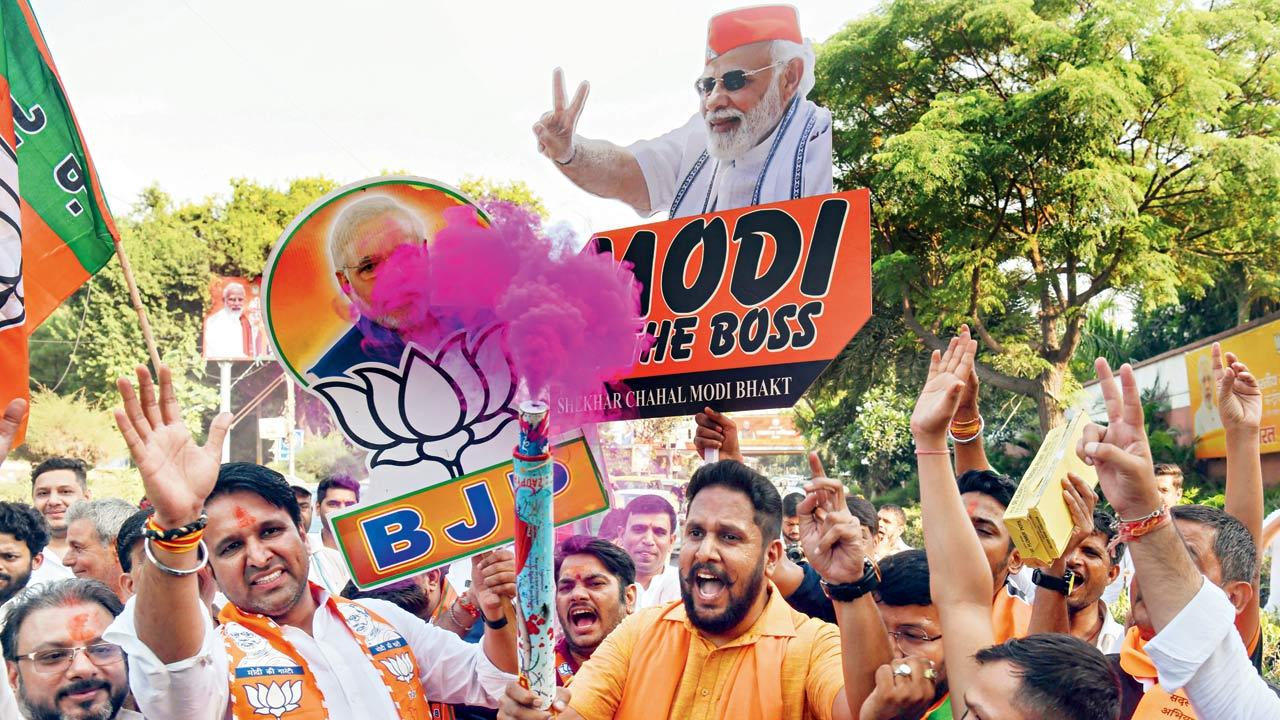 BJP supporters holding placards of PM Modi celebrate