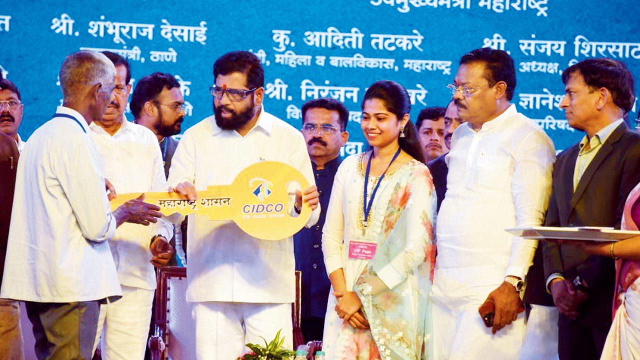 CM Eknath Shinde hands over the key of the new house to a survivor at a function in Navi Mumbai