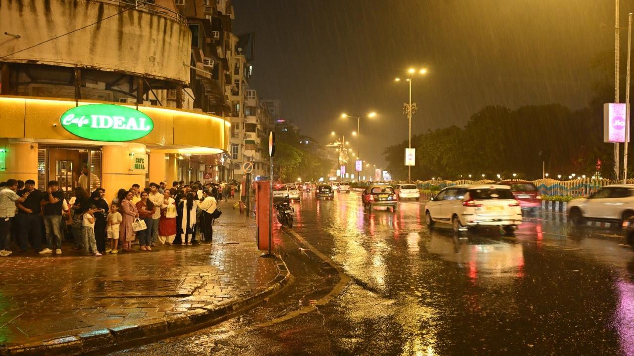 Revellers who had stepped out on Sunday evening take shelter under a building in Girgaon