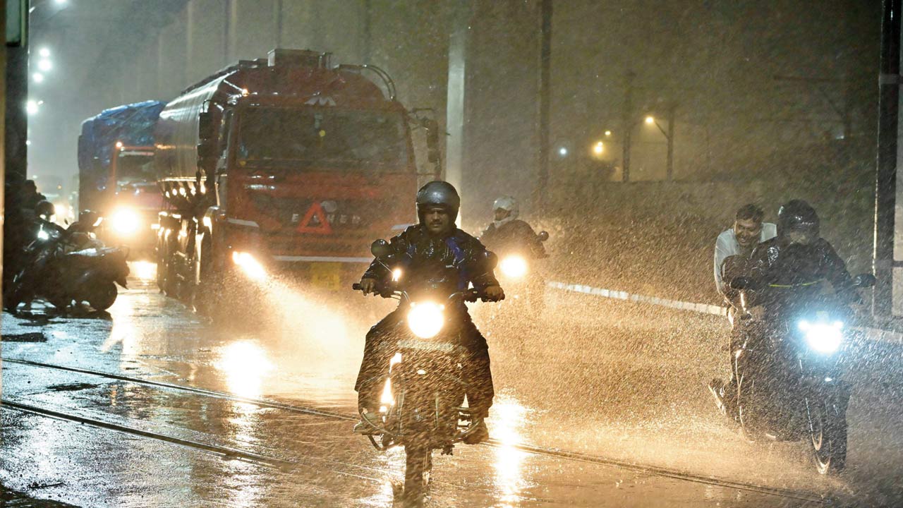 Mumbaikars caught in the sudden downpour at Sewri. Pic/Shadab Khan