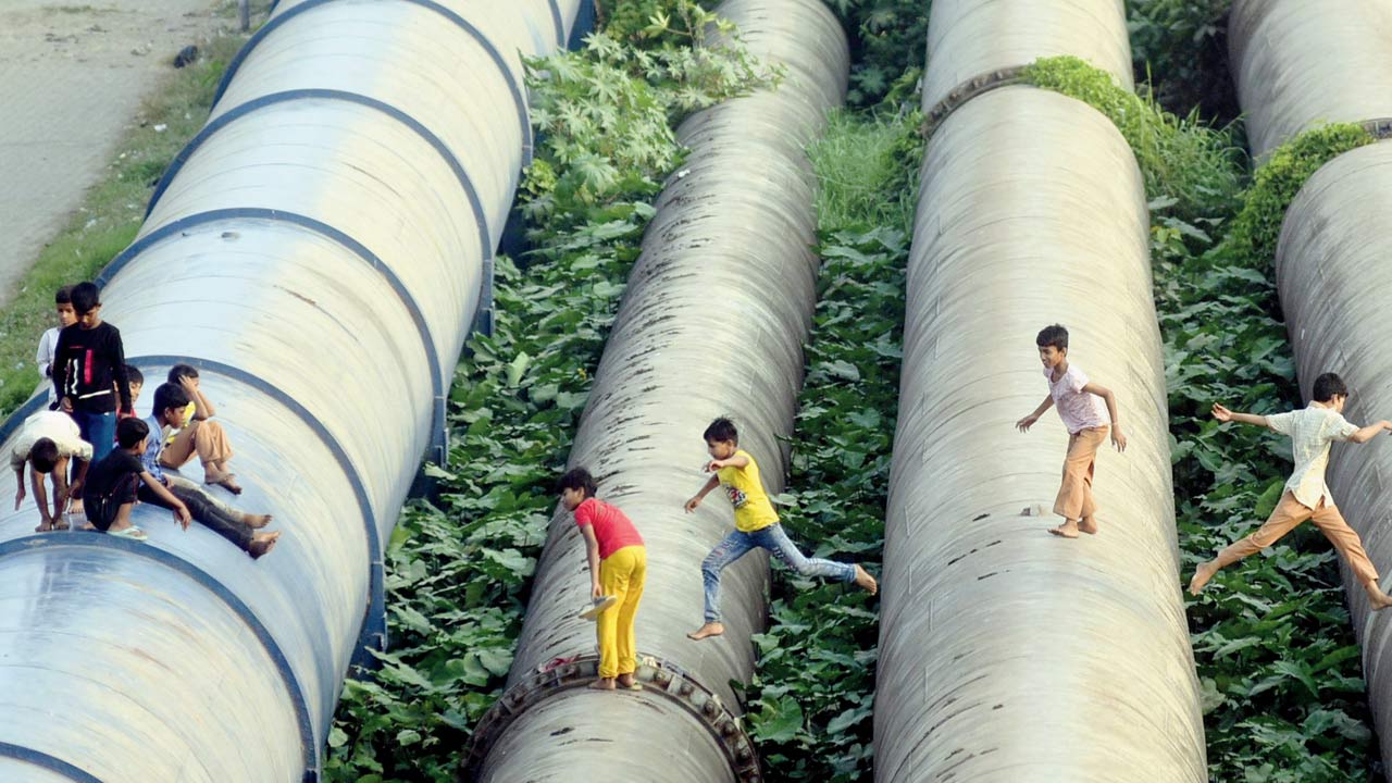 Kids playing on water pipelines in Bandra. Pic/Atul Kamble