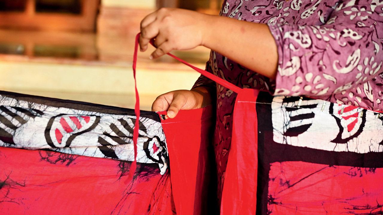 The saree comes with a string closure, as well as a hook. Tie the string first and then attach the hook